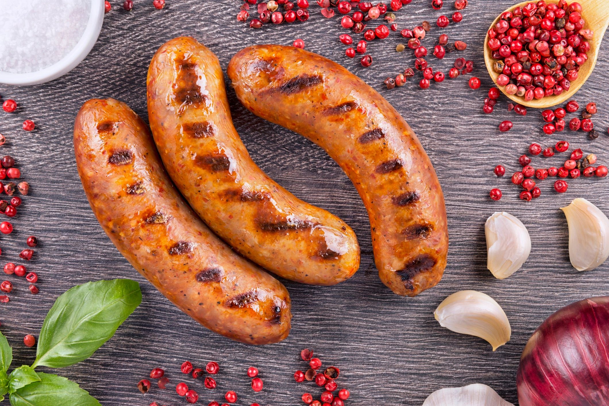 Grilled sausage on a wooden board with spices